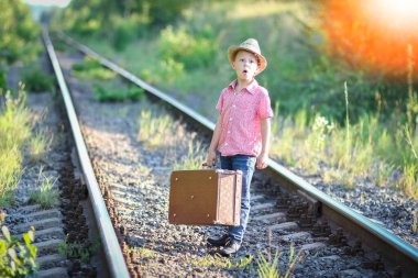 Kovboy çocuk bavulu ve tren yolu batı seyahat konseptiyle