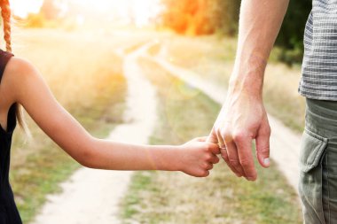 Ebeveyn, küçük bir çocuk konsepti ailesinin elini tutar.