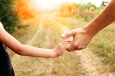 Ebeveyn, küçük bir çocuk konsepti ailesinin elini tutar.