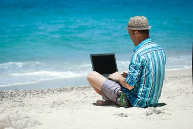 Happy man guy with laptop near the seashore weekend travel