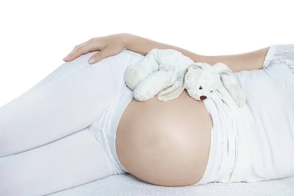 stock image Happy pregnant girl lies on white background