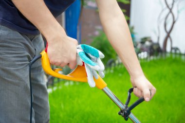 Bahçedeki çim biçme makinesi ve adam