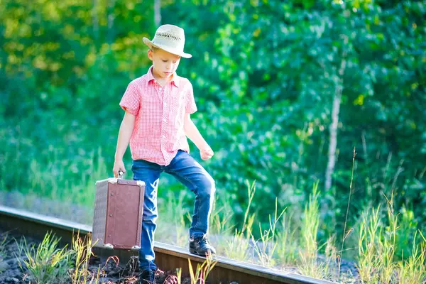 Kovboy çocuk bavulu ve tren yolu batı seyahat konseptiyle