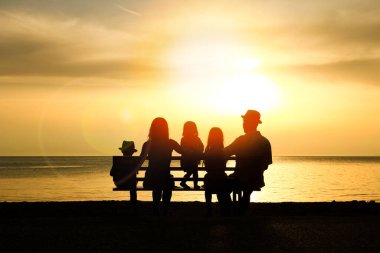 Doğada mutlu bir aile deniz kenarında bir siluette
