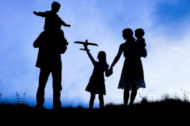 Deniz kenarında mutlu bir aile, doğanın siluetinde.