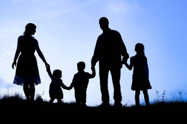 Deniz kenarında mutlu bir aile, doğanın siluetinde.