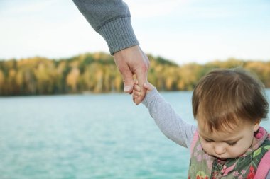 Deniz kenarındaki anne ve babanın güzel elleri.
