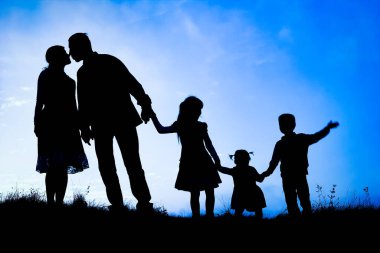 Deniz kenarında mutlu bir aile, doğanın siluetinde.