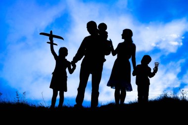 Deniz kenarında mutlu bir aile, doğanın siluetinde.