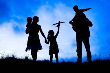 Deniz kenarında mutlu bir aile, doğanın siluetinde.