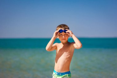 Doğada deniz kenarında oynayan mutlu çocuk.