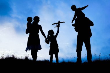 Deniz kenarında mutlu bir aile, doğanın siluetinde.