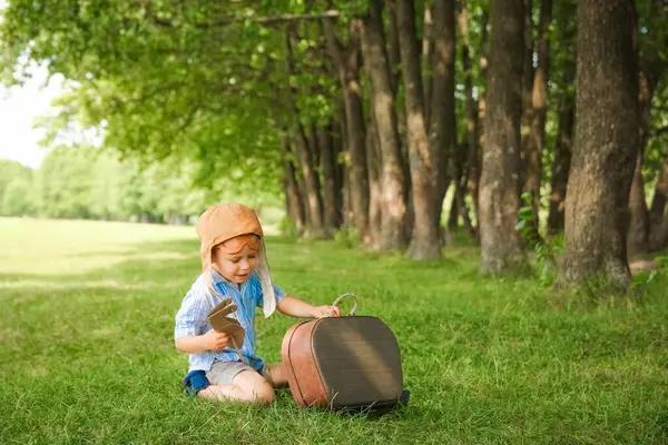 Uçağın yanındaki bebek parkta doğayla oynuyor. Tatil pilotu..