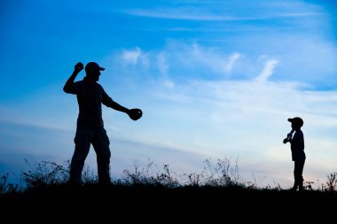 Ailesi parkta beyzbol oynayan mutlu bir çocuk.