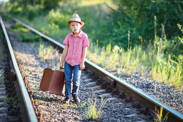 Kovboy çocuk bavulu ve tren yolu batı seyahat konseptiyle