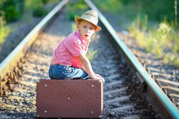 Kovboy çocuk bavulu ve tren yolu batı seyahat konseptiyle