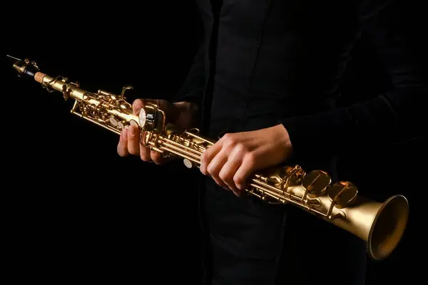 stock image soprano saxophone in the hands of a girl on a black background