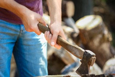 Baltalı ülke geçmişi olan bir adam odun kesiyor.
