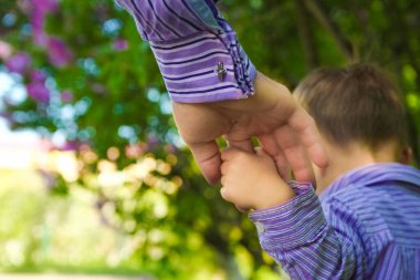 Mutlu bir geçmişi olan çocuğun elini tutan ebeveyn.