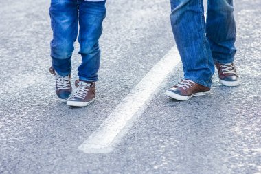 Anne ve babanın güzel ayakları parkta doğa yolculuğunda yolda.