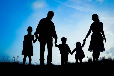 Deniz kenarında mutlu bir aile, doğanın siluetinde.