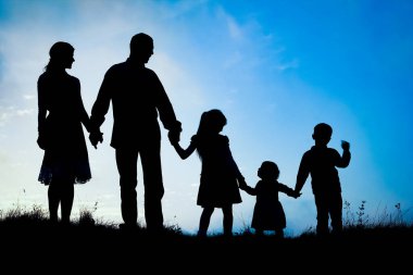 Deniz kenarında mutlu bir aile, doğanın siluetinde.