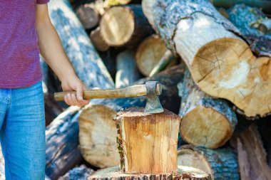 man chopping wood with an ax country background clipart