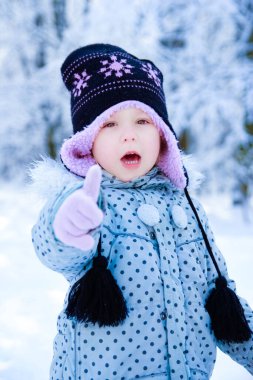 Mutlu çocuk kışın parkta oynuyor.