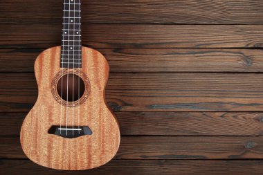 Kahverengi ahşap arka planda ukulele gitar