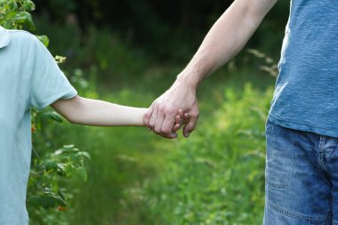 Baba, oğlunun elini tutarak doğa konseptini destekliyor.