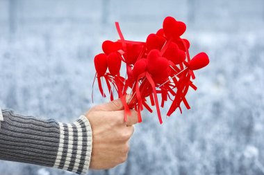 In the hands of the heart in winter on the road in the park travel background