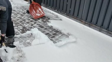 Mutlu bir baba ve oğlu kışın evin yakınındaki karları temizliyor.