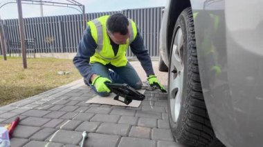 Sokakta lastik değiştiren bir adam doğada yaz lastiği olur.