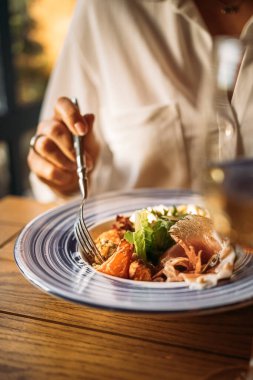 Restoran masasında bir kişi salata yiyor.