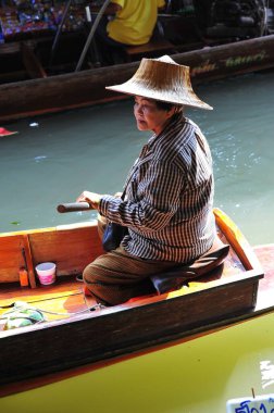 Damnoen Saduak Yüzen Pazarı 'nda çalışan renkli kadınların güzel bir manzarası. Tayland 5, 2012.