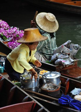 Damnoen Saduak Yüzen Pazarı 'nda çalışan renkli kadınların güzel bir manzarası. Tayland 5, 2012.