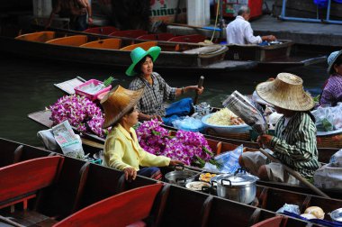 Damnoen Saduak Yüzen Pazarı 'nda çalışan renkli kadınların güzel bir manzarası. Tayland 5, 2012.