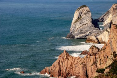 Portekiz 'deki Cape Roca kıyılarında mavi okyanusta bir uçurum 