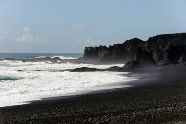 İzlanda 'nın güney kıyısındaki kara sahilde dalgalar