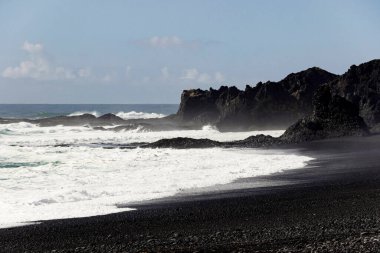 İzlanda 'nın güney kıyısındaki kara sahilde dalgalar