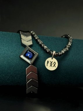 Gümüşten yapılmış doğal taştan yapılmış şık bir bilezik ve rünlerle süslenmiş bir kolye. Yüksek kalite fotoğraf