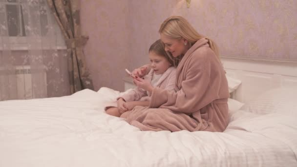 Eine Frau Und Ein Mädchen Kleidern Sitzen Auf Dem Bett — Stockvideo