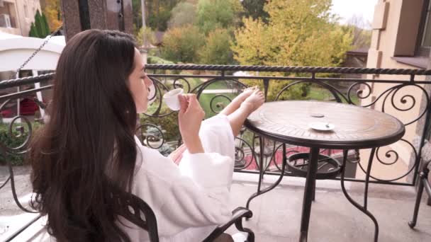 Back View Long Haired Brunette White Gown Sitting Terrace Drinking — Stockvideo