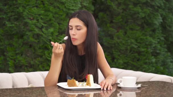 Una Foto Una Joven Morena Guapa Comiendo Una Tarta Sentada — Vídeo de stock