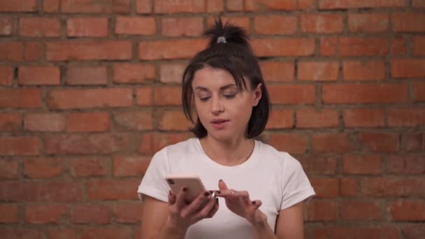 Närbild Ung Flicka Isolerad Mot Tegelvägg Bakgrund Kvinnan Använder Mobiltelefon — Stockvideo