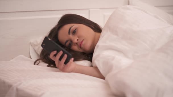 Closeup Pretty Long Haired Brunette Lying Sidelong Bed Looking Phone — 비디오