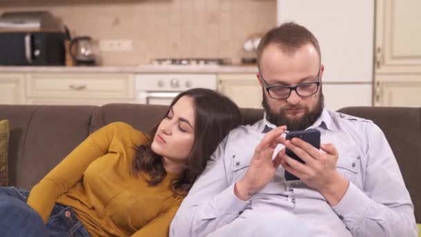Pretty Brunette Leans Her Head Bearded Man Glasses Sitting Sofa — Stockvideo