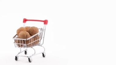 Yarım kare. İçi ceviz dolu süpermarket arabasının makro çekimi turntable 'da dönüyor. Siyah arkaplanda izole edilmiş.