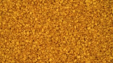 Top view from above of gold bar shaped crystals heap rotating. Close-up.