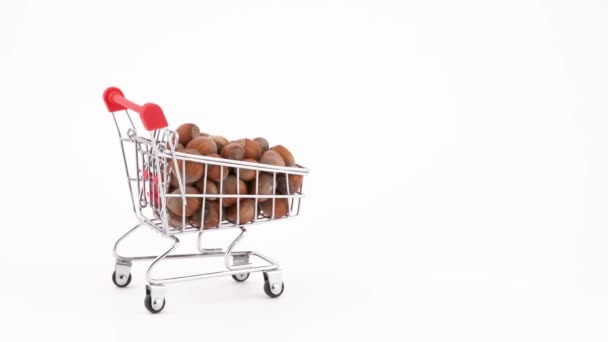 Shopping Cart Filled Hazelnuts Moving Forward Isolated White Background Close — Stockvideo